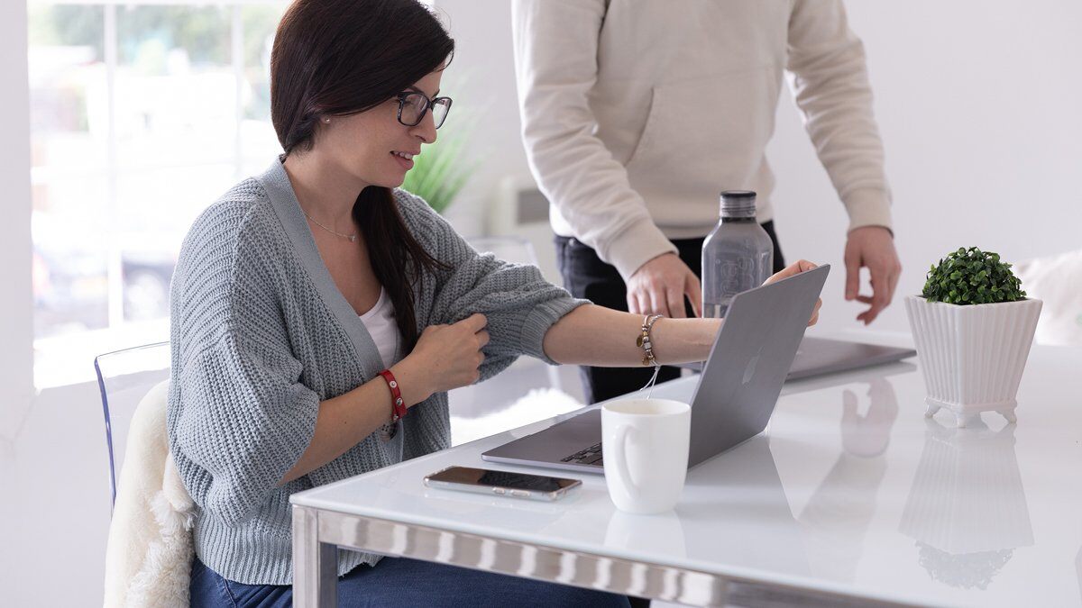 A woman (Monia) sitting at a desk on her laptop.